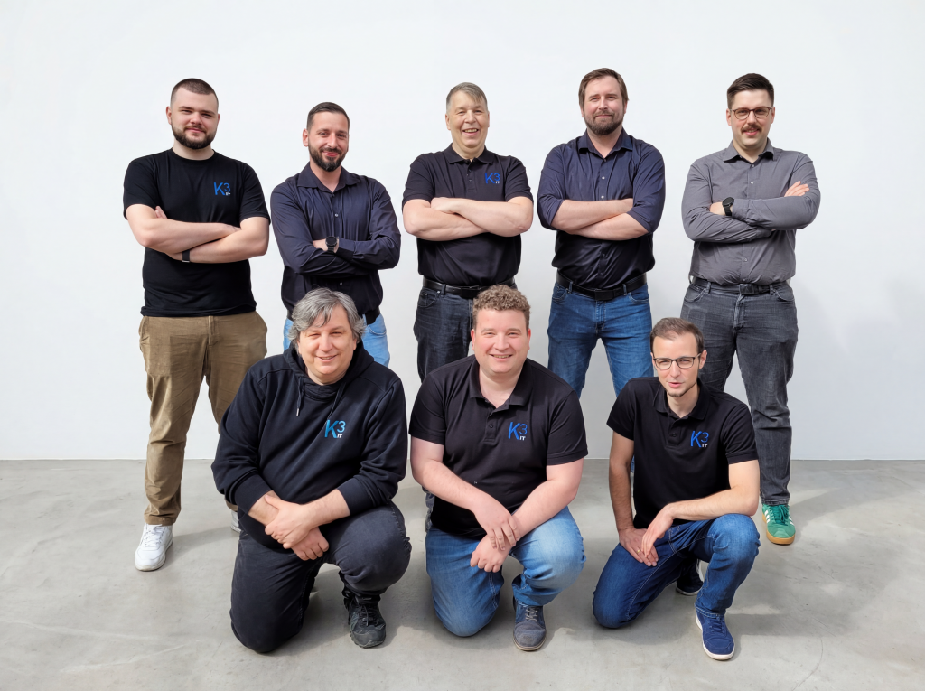 Gruppenbild der Konzept3 IT Mitarbeiter. 5 Mitarbeiter stehend und davor 3 Mitarbeiter kniend/hockend.