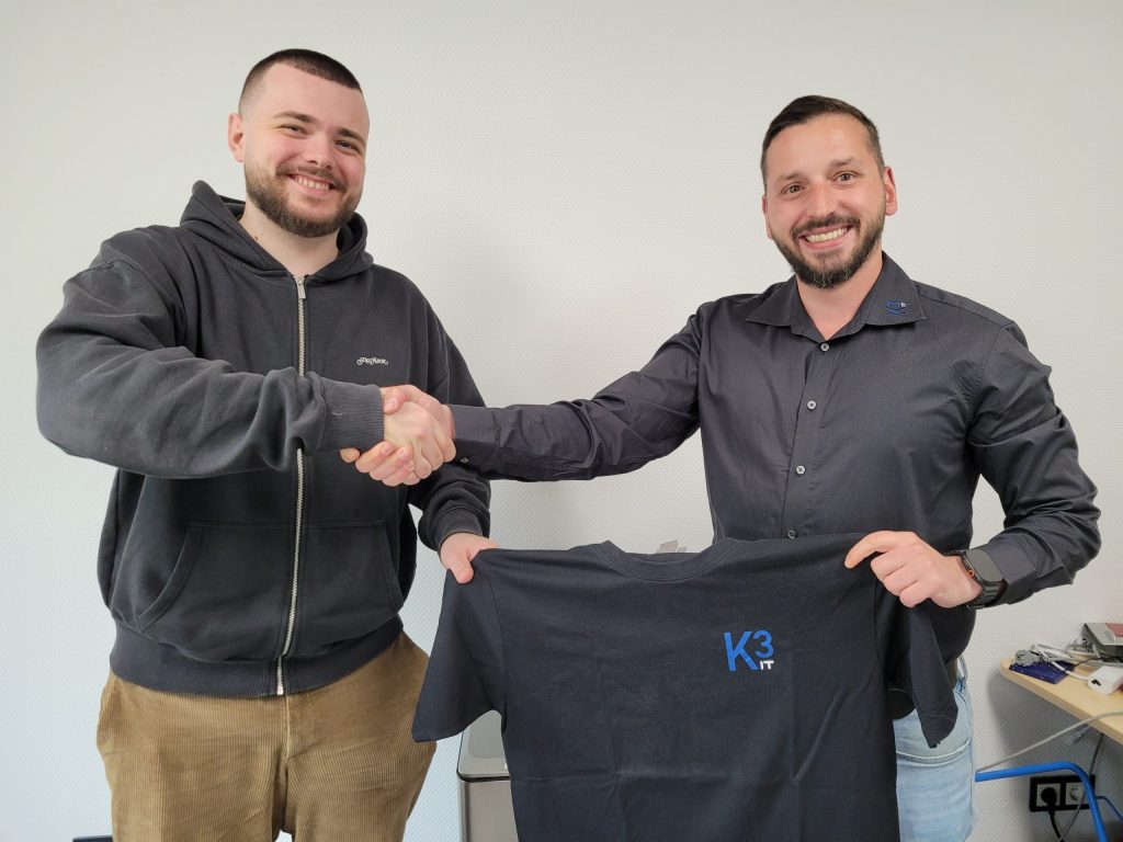 Das Bild zeigt den Geschäftsführer Qendrim Sallauka beim Handshake und der Trikotübergabe an unseren neuen Mitarbeiter Denis Luchs.