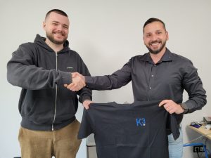 Das Bild zeigt den Geschäftsführer Qendrim Sallauka beim Handshake und der Trikotübergabe an unseren neuen Mitarbeiter Denis Luchs.